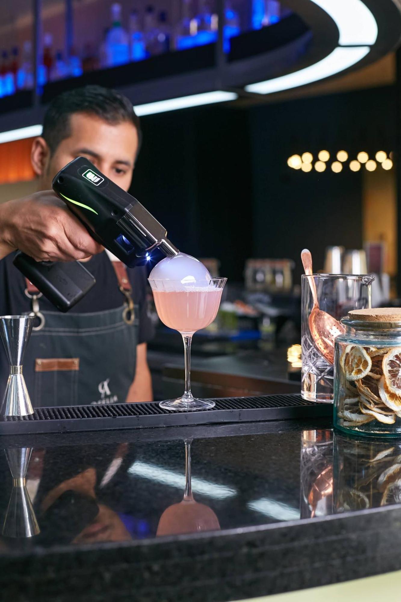 Pullman Santiago Vitacura المظهر الخارجي الصورة A bartender using a blowtorch to cook a cocktail